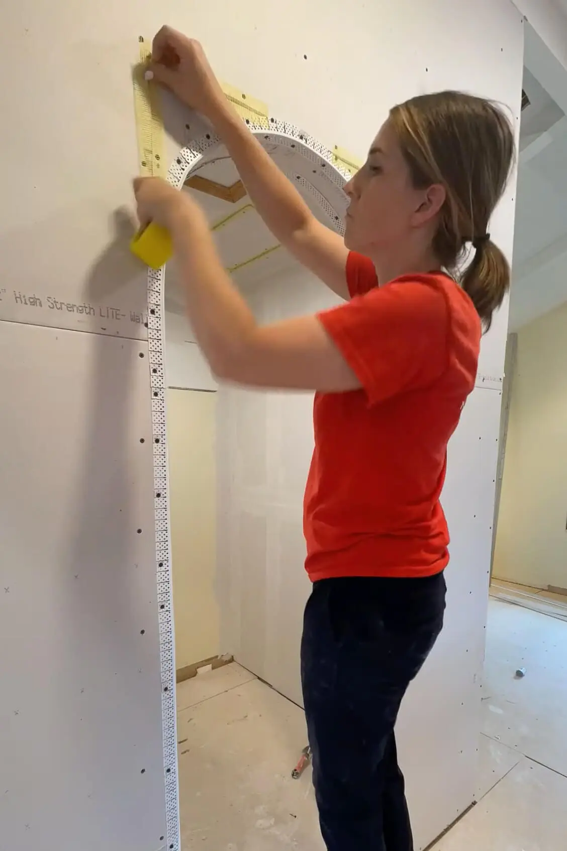 Adding mesh drywall tape to an arched doorway before using drywall mud.